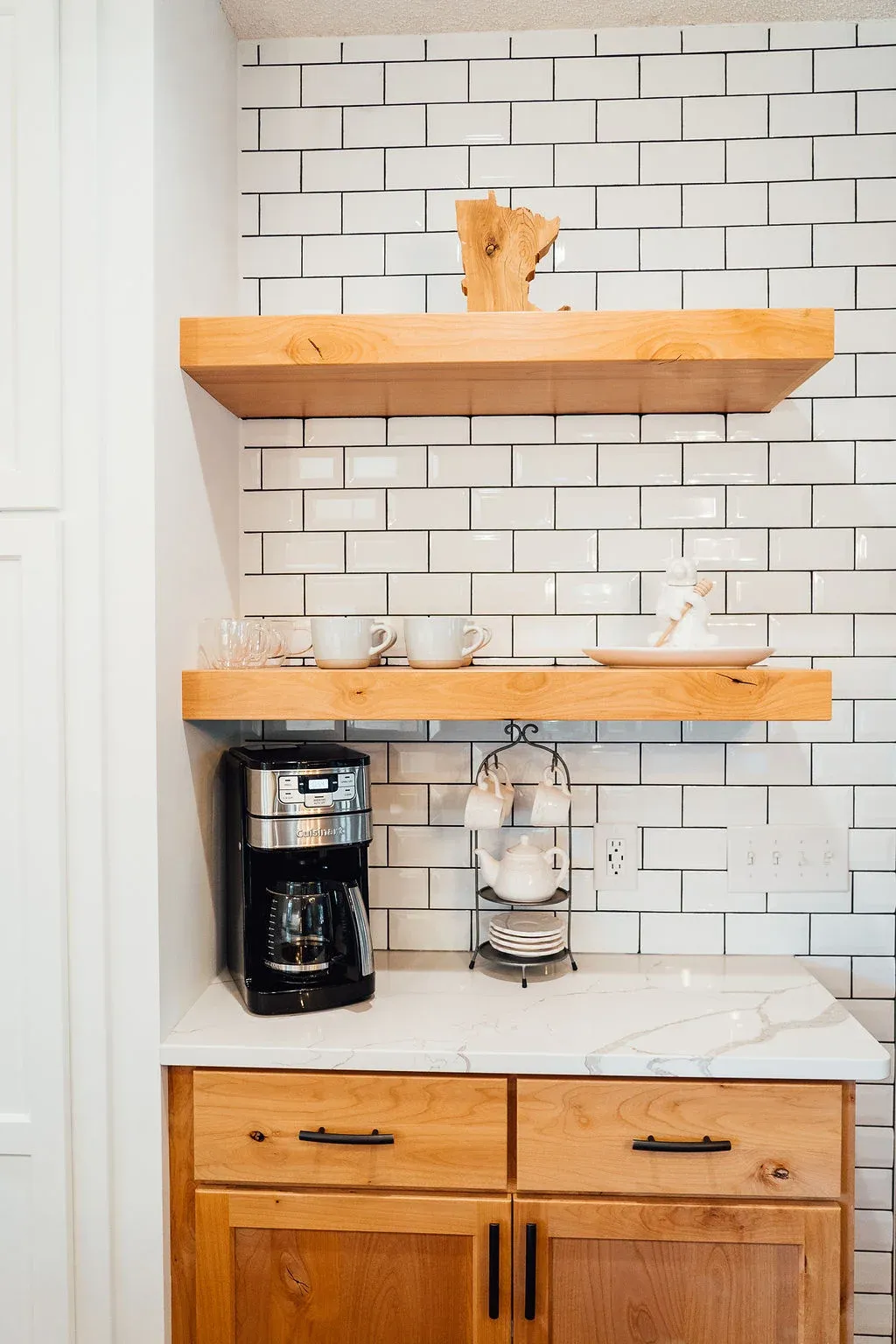 Coffee bar with backsplash tile extended to the ceiling around floating shelves in Lakeville kitchen remodel
