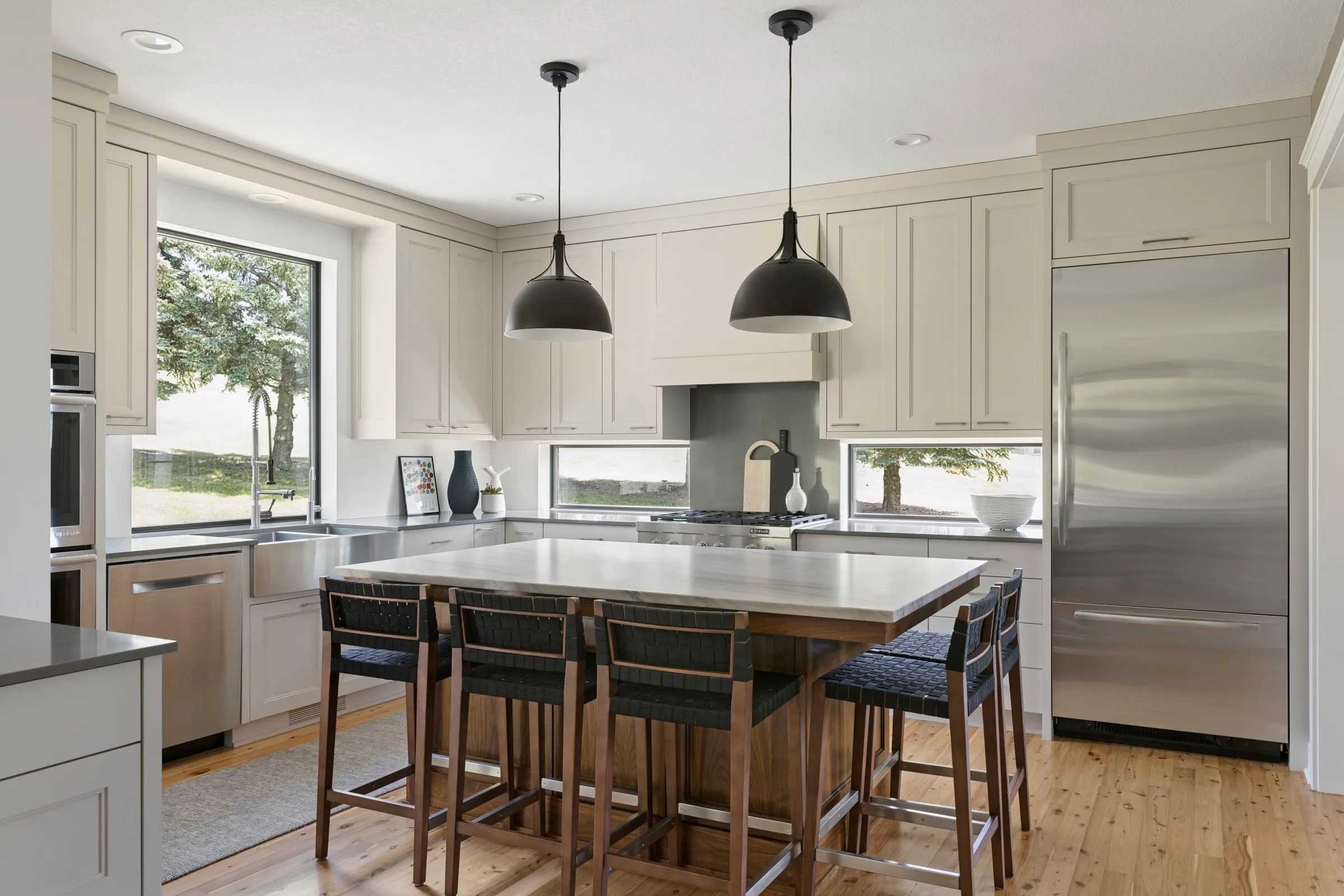 Black walnut island with woven bar stools anchoring a remodeled Lakeville kitchen